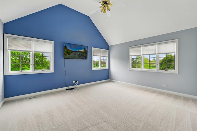 carpeted empty room featuring vaulted ceiling, ceiling fan, and baseboards