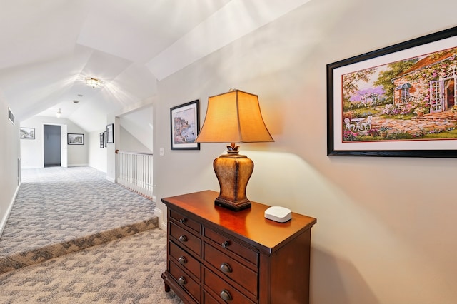 corridor with carpet floors, lofted ceiling, and baseboards