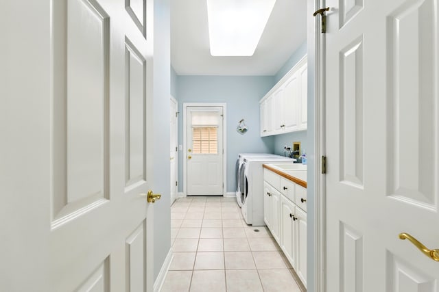 laundry room with cabinet space, washing machine and clothes dryer, light tile patterned floors, and baseboards