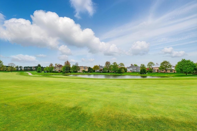 view of home's community with a water view, a yard, golf course view, and a residential view