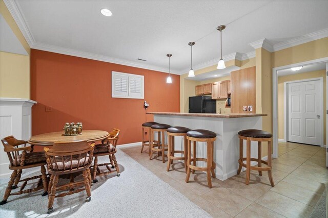 1721 Partridge Pt, Normal, IL 61761 - kitchen featuring freestanding refrigerator, a kitchen breakfast bar, ornamental molding, light brown cabinets, and pendant lighting