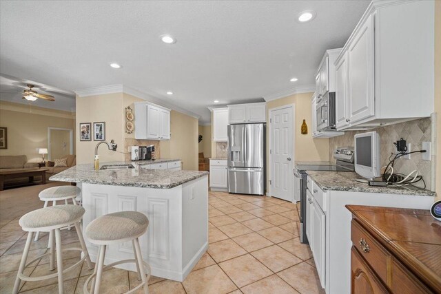 1721 Partridge Pt, Normal, IL 61761 - kitchen featuring appliances with stainless steel finishes, a peninsula, crown molding, backsplash, and open floor plan