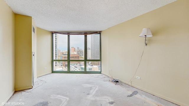 111 W Maple St Unit 1001, Chicago, IL 60610 - spare room featuring floor to ceiling windows, a city view, a textured ceiling, and baseboards