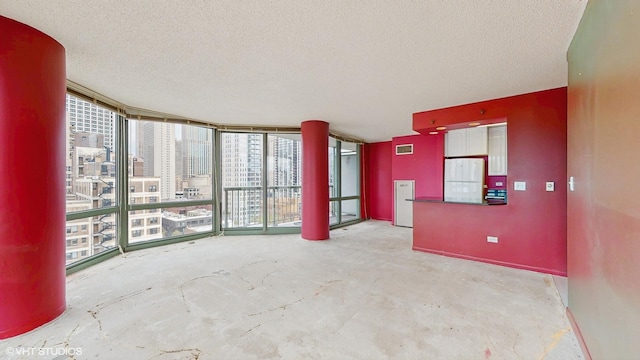 111 W Maple St Unit 1001, Chicago, IL 60610 - empty room with a textured ceiling, healthy amount of natural light, concrete floors, and a city view