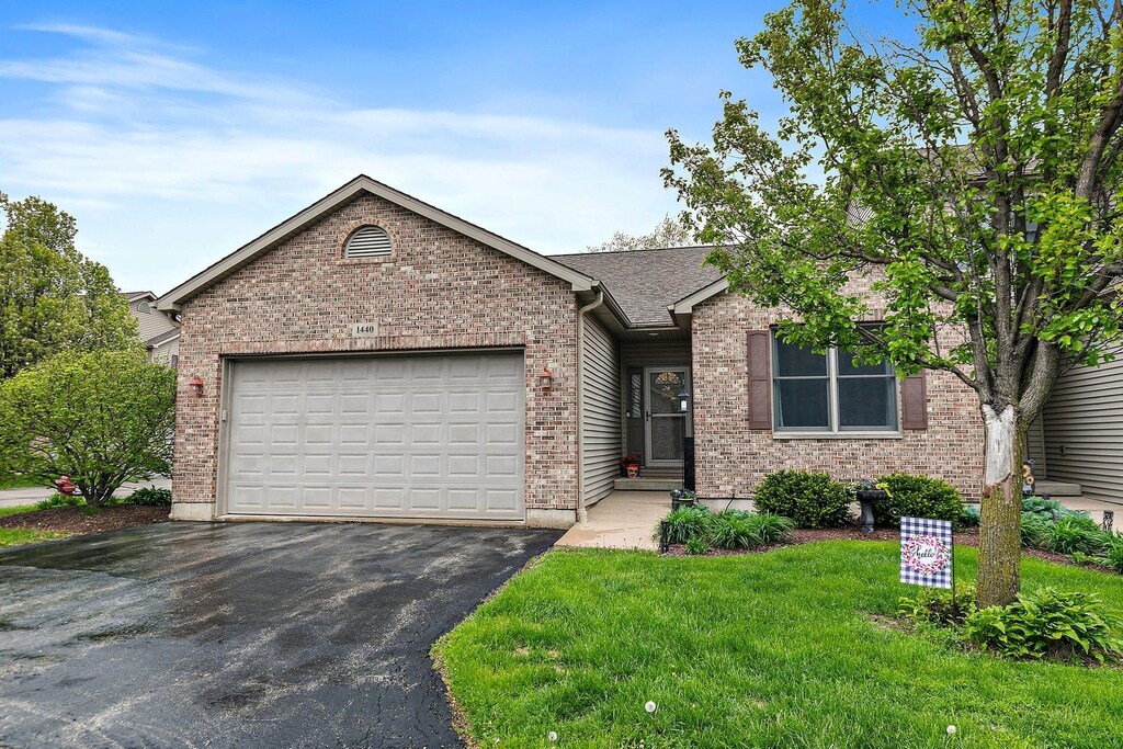 1440 Ridge Dr, Sycamore, IL 60178 - single story home with driveway, brick siding, a garage, and a front yard