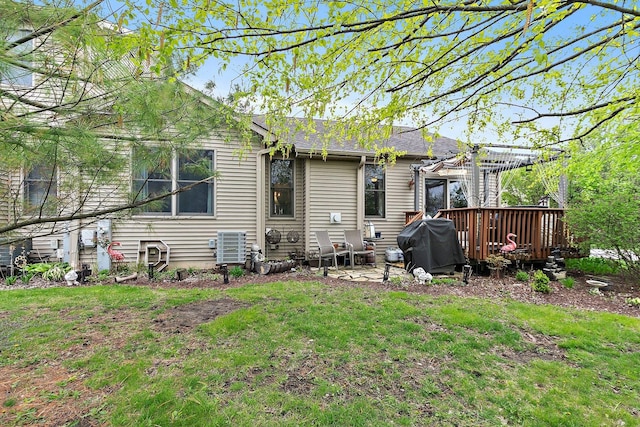 rear view of house with a yard, a pergola, and a deck