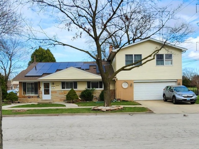 5849 Emerson St, Morton Grove, IL 60053 - view of front of home featuring roof mounted solar panels, a garage, a chimney, a front lawn, and driveway