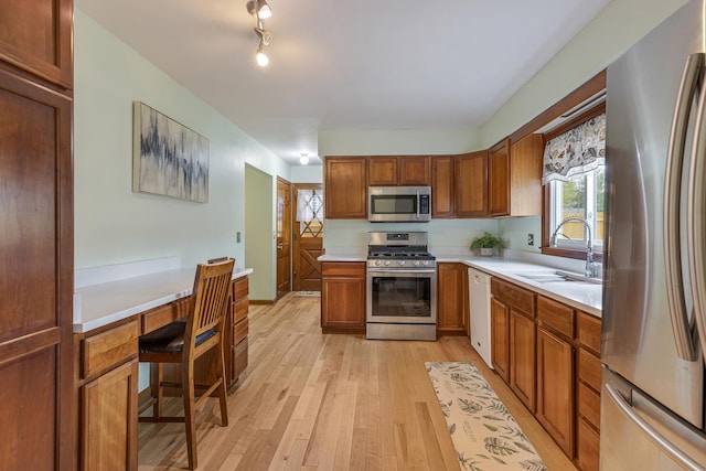 19 S 11th St, Saint Charles, IL 60174 - kitchen featuring stainless steel appliances, a sink, light wood finished floors, light countertops, and brown cabinets
