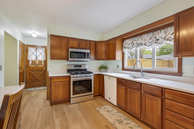 19 S 11th St, Saint Charles, IL 60174 - kitchen featuring appliances with stainless steel finishes, a sink, light countertops, light wood-style flooring, and brown cabinets