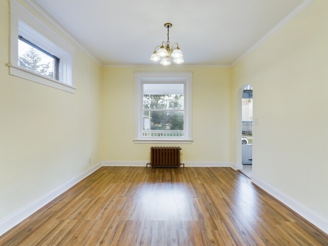 625 Ingraham Ave, Calumet City, IL 60409 - unfurnished room with radiator, wood finished floors, crown molding, arched walkways, and a notable chandelier