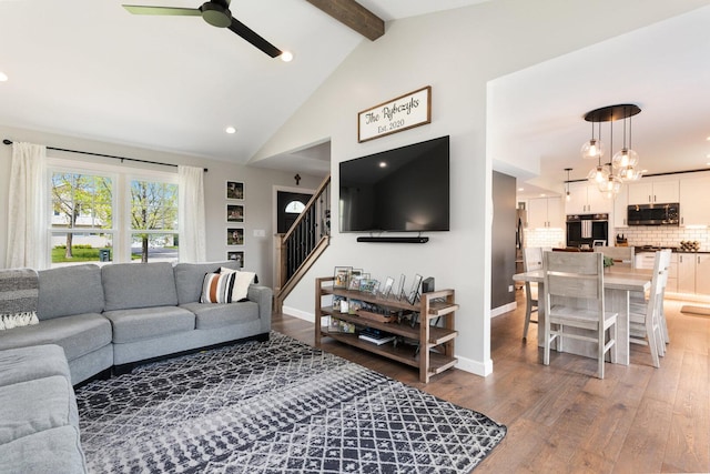 living area featuring wood finished floors, recessed lighting, stairway, a ceiling fan, and vaulted ceiling with beams
