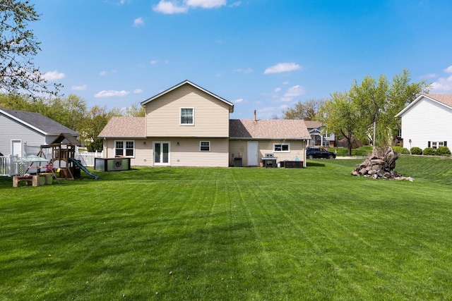 rear view of house featuring a lawn