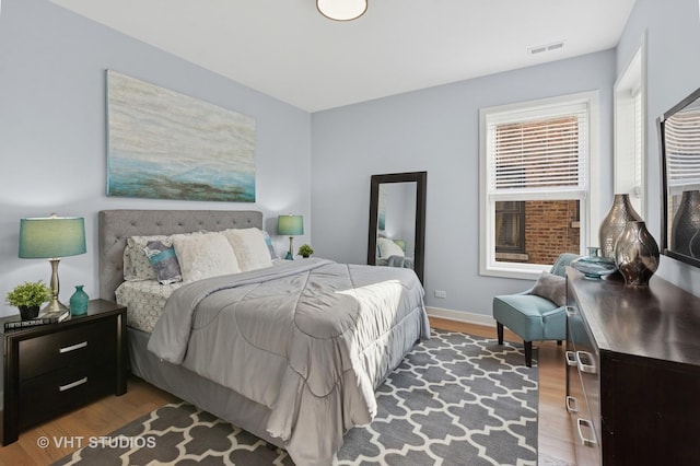 847 W Ainslie St Unit 2E, Chicago, IL 60640 - bedroom featuring baseboards, visible vents, and wood finished floors