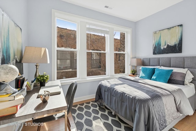 847 W Ainslie St Unit 2E, Chicago, IL 60640 - bedroom with baseboards, visible vents, and wood finished floors