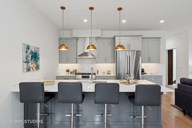 847 W Ainslie St Unit 2E, Chicago, IL 60640 - kitchen with wood finished floors, wall chimney range hood, light countertops, appliances with stainless steel finishes, and gray cabinets