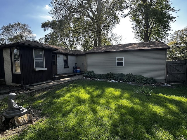 rear view of house with fence and a lawn