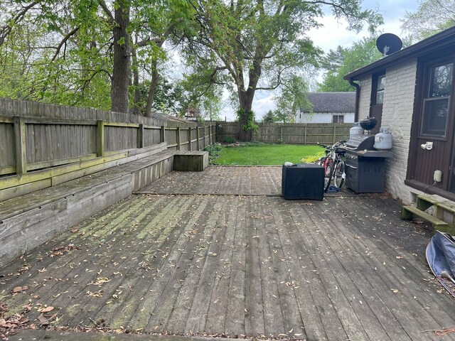 deck with a lawn and a fenced backyard