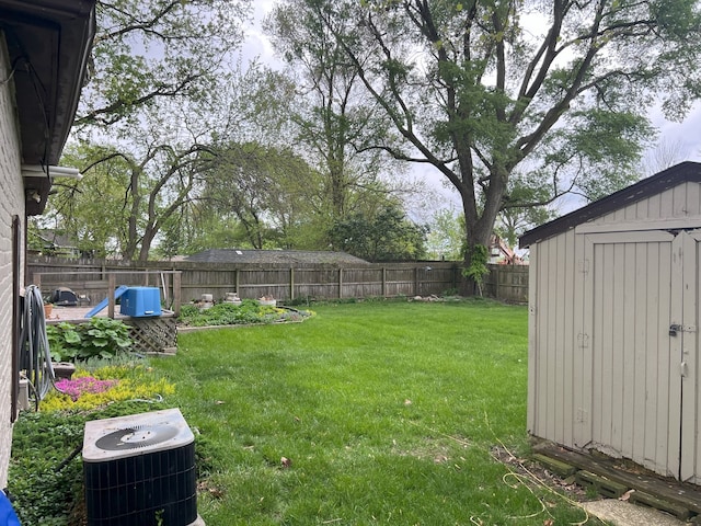 view of yard with central AC, an outdoor structure, a storage shed, and a fenced backyard