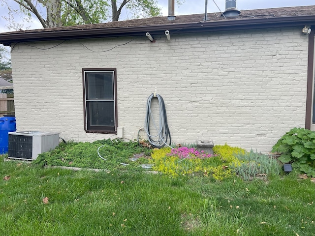 view of side of property featuring central AC unit and brick siding