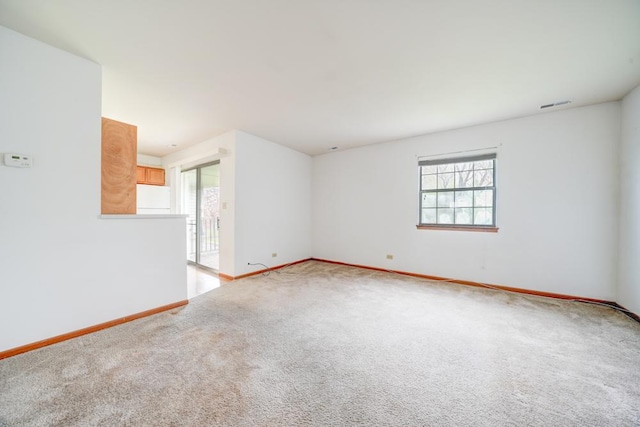 empty room with light colored carpet, visible vents, and baseboards