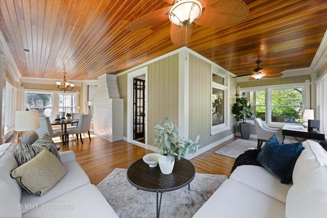 living room featuring wooden ceiling, a chandelier, crown molding, a ceiling fan, and wood finished floors