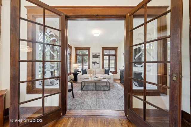 doorway to outside with french doors, wood finished floors, and baseboards