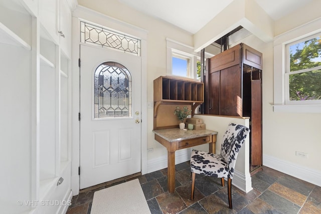 entrance foyer with stone tile floors and baseboards