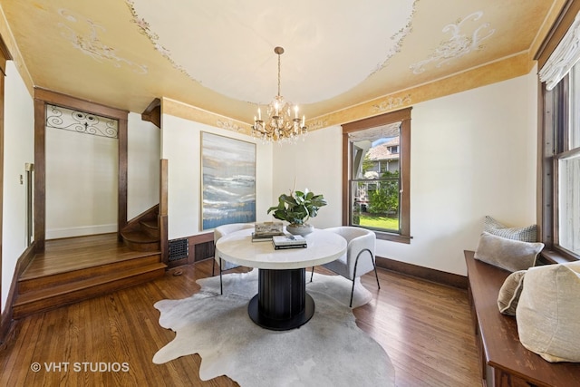 dining area featuring baseboards, a chandelier, and wood finished floors
