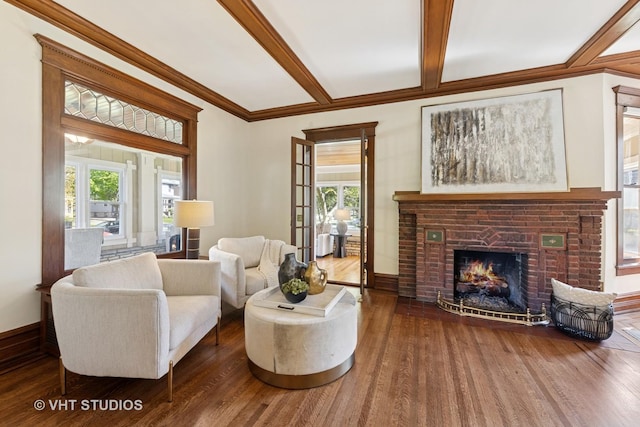 living room featuring wood finished floors, healthy amount of natural light, a brick fireplace, beam ceiling, and ornamental molding