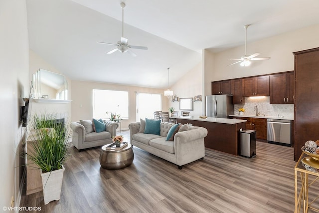 6361 Patricia Dr, Matteson, IL 60443 - living area with a ceiling fan, high vaulted ceiling, plenty of natural light, light wood-style flooring, and a chandelier