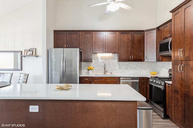 6361 Patricia Dr, Matteson, IL 60443 - kitchen with stainless steel appliances, a sink, ceiling fan, backsplash, and light wood-style flooring