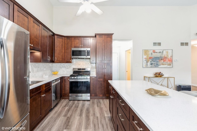 6361 Patricia Dr, Matteson, IL 60443 - kitchen featuring stainless steel appliances, light countertops, ceiling fan, light wood-style flooring, and tasteful backsplash