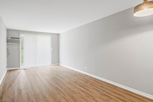 764 Terrace Ct Unit A, Elgin, IL 60120 - unfurnished living room featuring a wall mounted air conditioner, wood finished floors, and baseboards