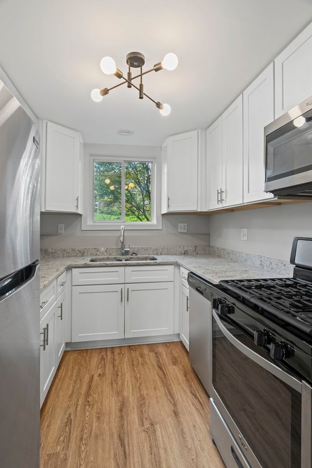 764 Terrace Ct Unit A, Elgin, IL 60120 - kitchen with a notable chandelier, white cabinetry, stainless steel appliances, and a sink