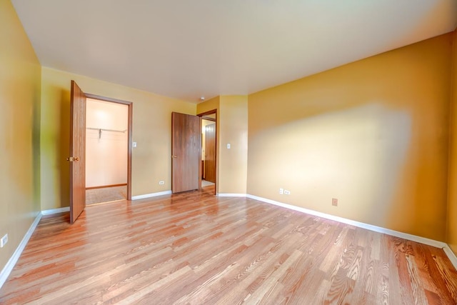 99 Gant Cir Unit C, Streamwood, IL 60107 - unfurnished bedroom with baseboards, a spacious closet, a closet, and light wood-style flooring