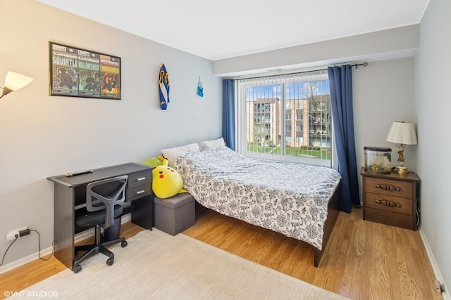 bedroom with baseboards and light wood-style flooring