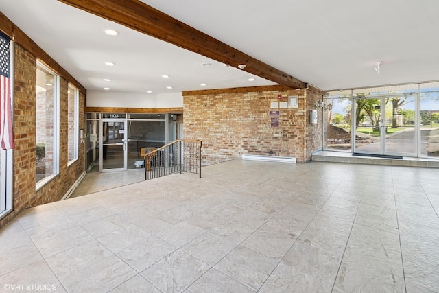 spare room with brick wall, beam ceiling, and recessed lighting