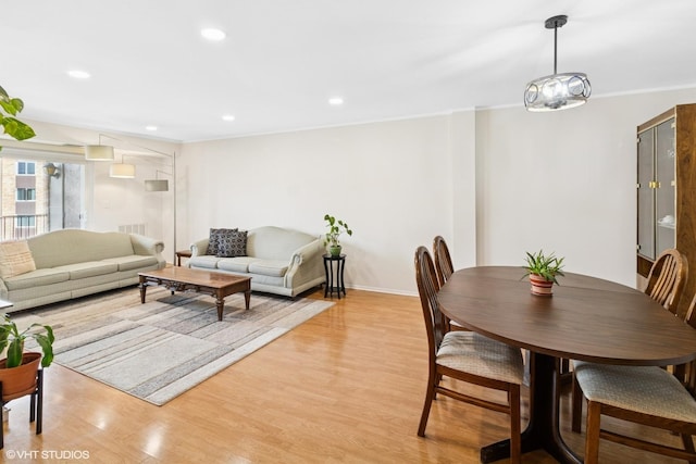 dining space featuring ornamental molding, recessed lighting, baseboards, and light wood-style floors