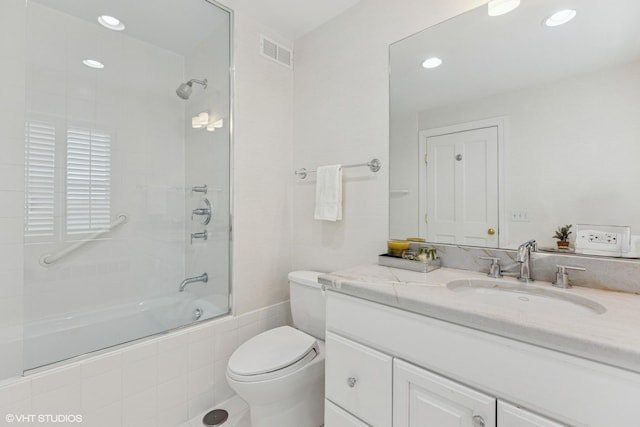 bathroom featuring tiled shower / bath combo, toilet, vanity, and recessed lighting
