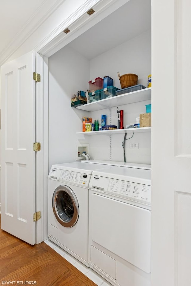 clothes washing area featuring independent washer and dryer and light wood-style flooring