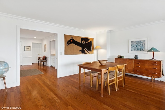 dining area with wood finished floors and ornamental molding