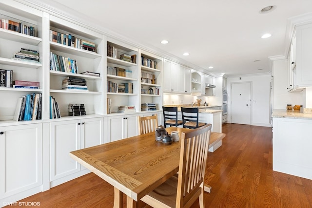 dining space featuring wood finished floors, recessed lighting, and crown molding