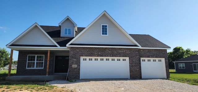 24415 W Quail Dr, Channahon, IL 60410 - traditional home with brick siding, a garage, covered porch, and driveway
