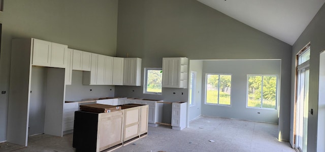 24415 W Quail Dr, Channahon, IL 60410 - kitchen with high vaulted ceiling, a kitchen island, healthy amount of natural light, and white cabinetry