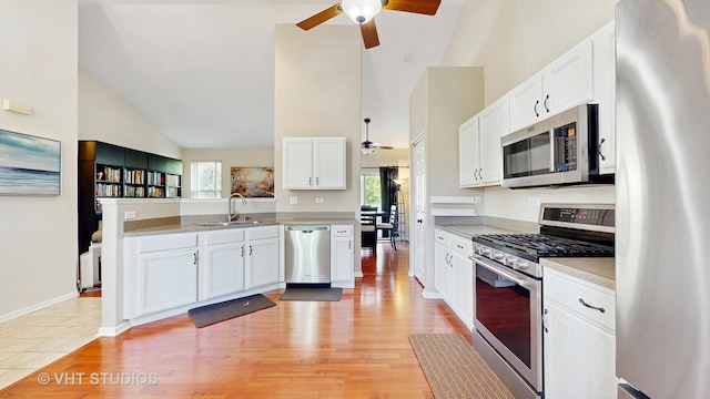 376 Willow Rd, Lakemoor, IL 60051 - kitchen with stainless steel appliances, ceiling fan, a peninsula, white cabinetry, and high vaulted ceiling