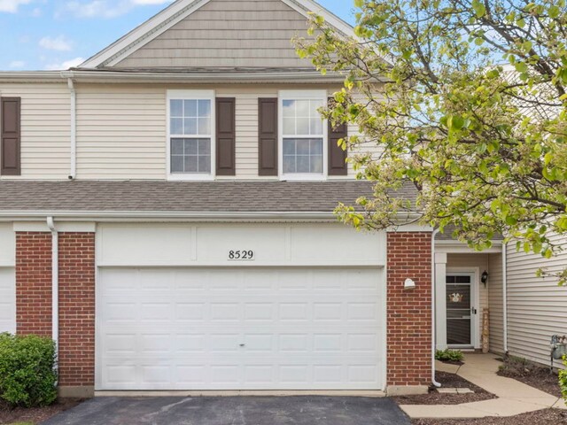 8529 Sawyer Ct, Joliet, IL 60431 - townhome / multi-family property with brick siding, asphalt driveway, roof with shingles, and a garage