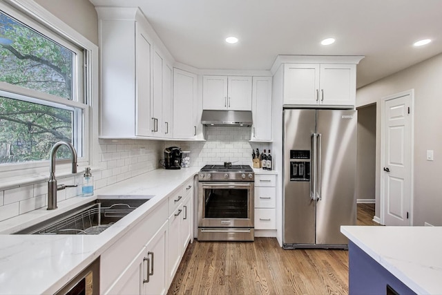 962 Thompson Blvd, Buffalo Grove, IL 60089 - kitchen featuring stainless steel appliances, under cabinet range hood, a sink, white cabinetry, and light stone countertops