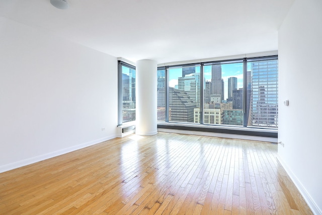 60 E Monroe St Unit 2705, Chicago, IL 60603 - spare room with wood-type flooring, baseboards, and a skyline view
