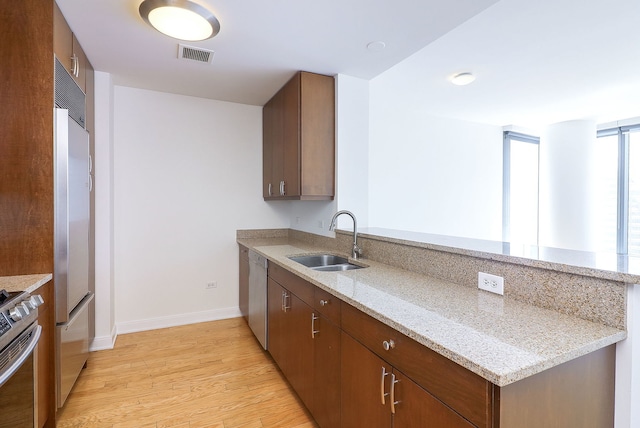 60 E Monroe St Unit 2705, Chicago, IL 60603 - kitchen with a sink, a peninsula, stainless steel appliances, light wood-style flooring, and baseboards