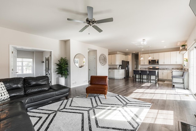 living area featuring a ceiling fan, a wealth of natural light, light wood-style flooring, and recessed lighting
